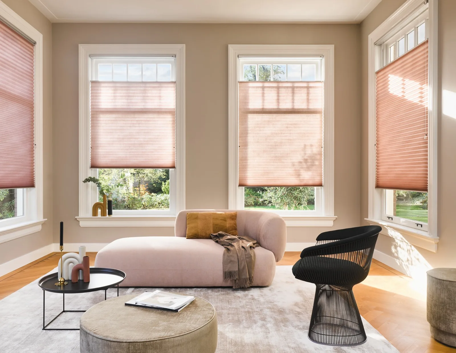 Pink Duette blinds across three bay windows in a lounge