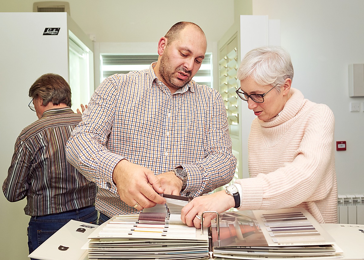 A specialist showing shutter and blind samples to a visitor at the Edinburgh Design Studio