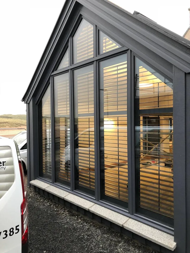 Outside view of a large trapezoidal gable with the newly applied shutters